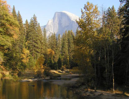 a boat in the middle of a lake with mountains and trees in the background